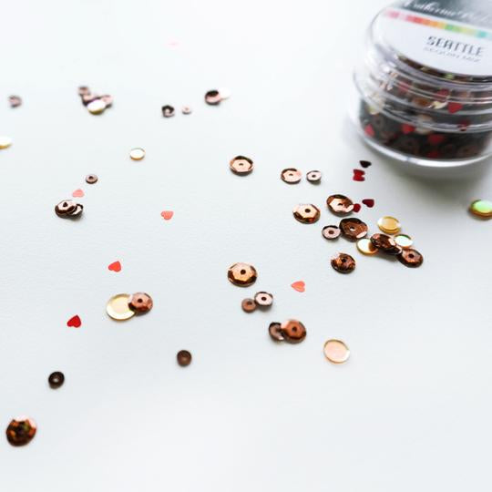 Catherine Pooler - Sequin Mix - Seattle. Home of the popular coffee café chain, Seattle, Washington is a perfect spot for sipping a hot cup of java on a chilly, rainy Pacific Northwest day. In celebration of the bean, the Seattle Sequin Mix is full of beautiful dark roasted brown and latte colored sequins with pops of metallic and hologram shine. Available at Embellish Away located in Bowmanville Ontario Canada.