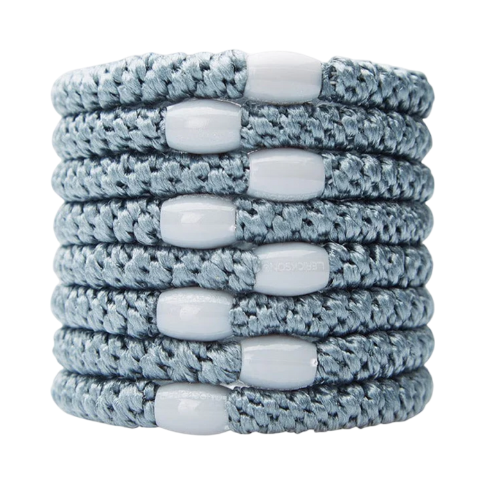 Stack of gray braided bracelets with white beads on a white background