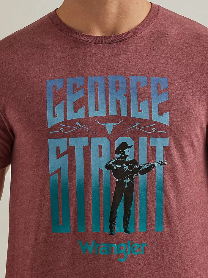 Closeup of front of a man wearing a short sleeve, crew neck Wrangler George Strait t-shirt in port color. featuring a sccreen print of "George Strait Wrangler" and a picture of George Strait holdiing a guitar.