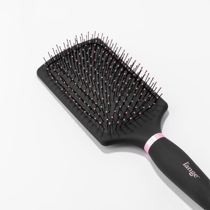 You can clearly see the rounded, pink-tipped bristles on the black nylon bristle brush.