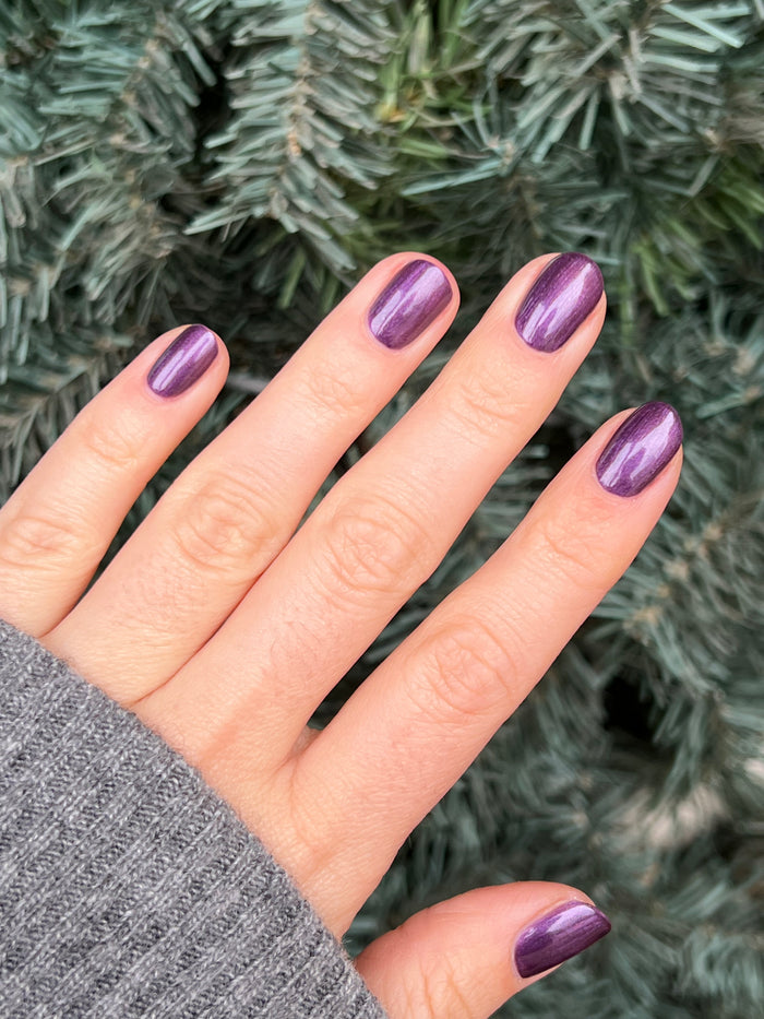 Hand with short nails painted in deep purple golden shimmer gel polish My Favorite Color by Olive and June