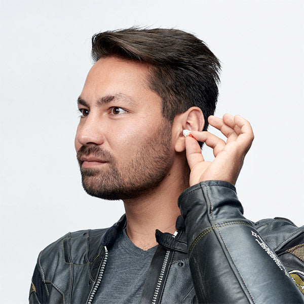 man inserting earplug