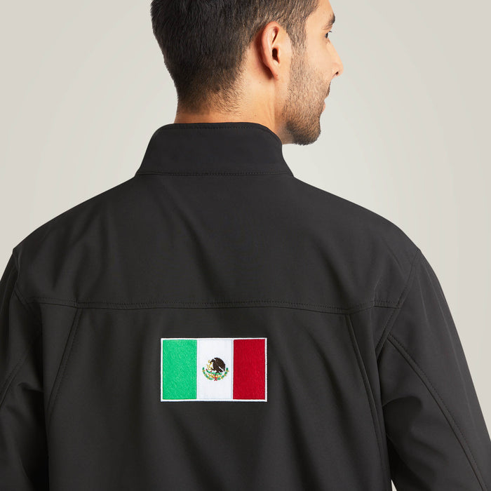 Men's Ariat softshell Team logo jacket in black with a blocked Ariat logo in white, green, and red representing the Mexican Flag. Rear view showing Mexican Flag patch.