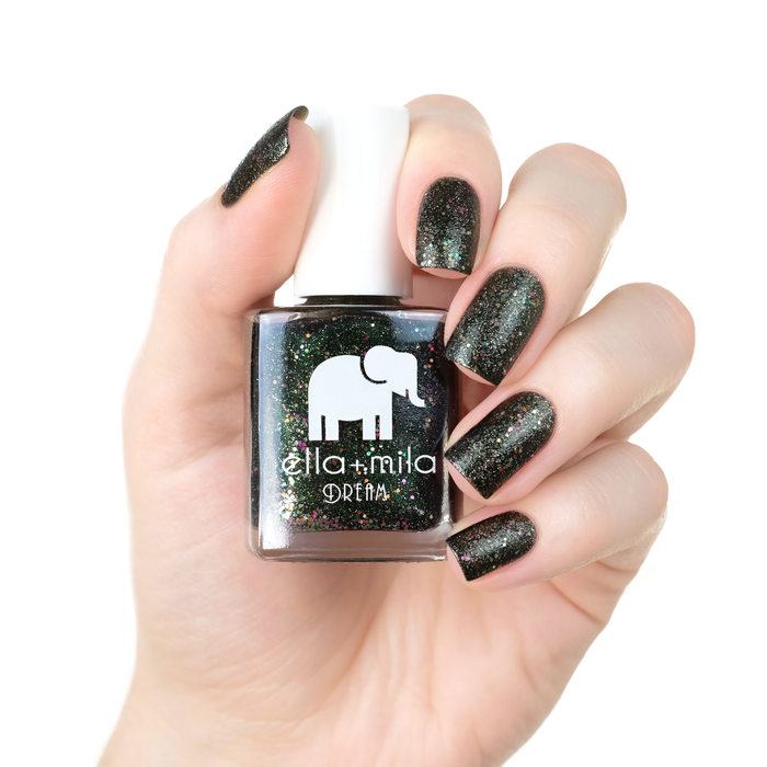 Black Magic black glitter nail polish manicure on a light skin tone with the bottle