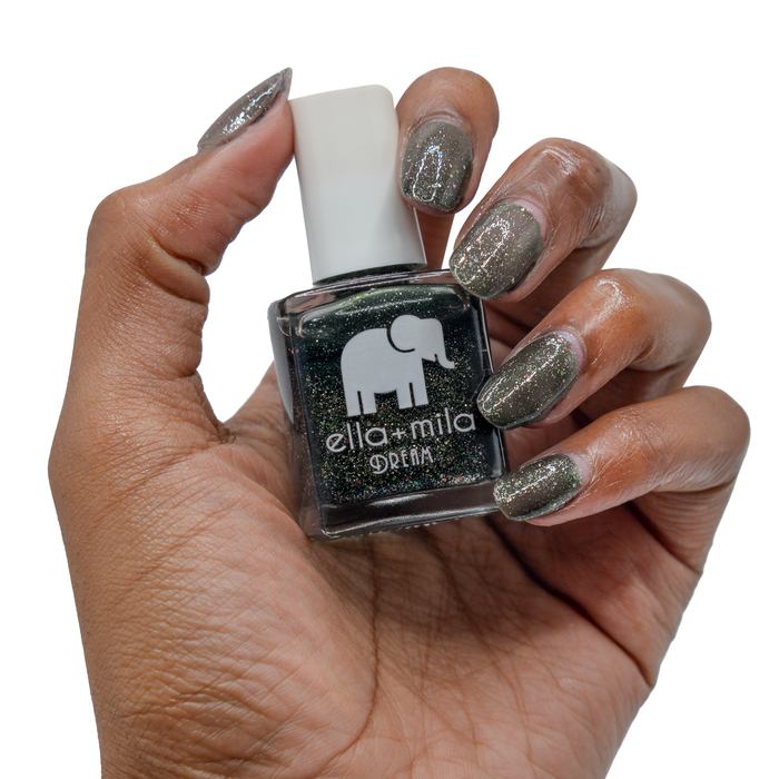 Black Magic glitter nail polish on a deep skin tone, hand holding the bottle