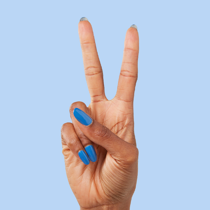 Hand showing peace sign with nails painted in Blue Canoe long-lasting polish for a stylish manicure look