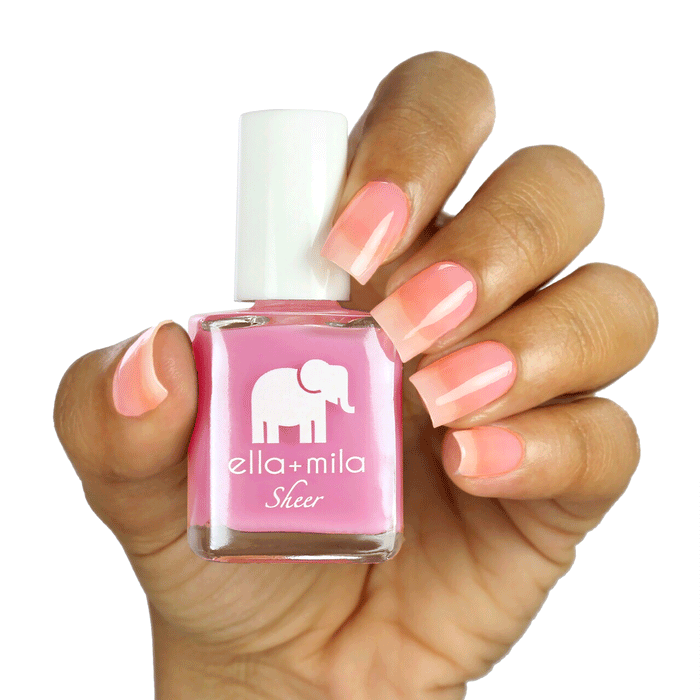 Brave sheer pink tint nail polish on a medium skin tone, hand holding the bottle