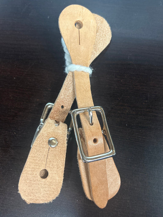 A pair of tan leather spur straps with a metal buckle designed for children's boots.