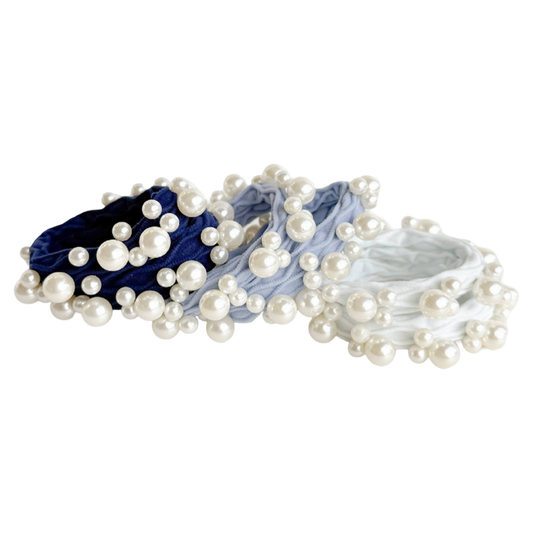 Set of pearl hair ties in blue, gray, and white on a white background