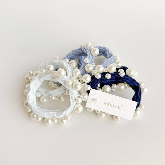 Set of pearl-adorned hair ties with a visible 'adorro' tag on a light background