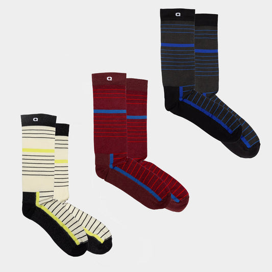 Three pairs of socks in different colors with horizontal stripes: one cream and black with yellow accents, one burgundy and red with gray, and one black and blue with gray toes and heels, arranged on a plain background.