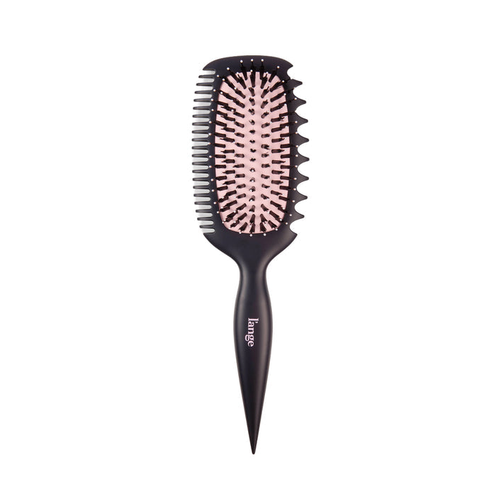 Oval paddle-style brush with a side comb edge, black handle, and pink cushion on a white background.