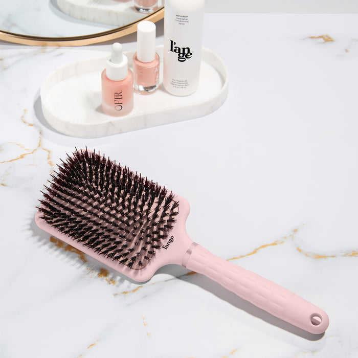 detangling padding brush with nylon and boar bristles  on a vanity