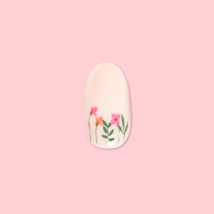 Floral Fields - Press-On | Medium | Oval showing a medium oval false nail with delicate red and orange floral designs on pale pink background