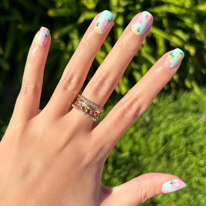 Full Floral - Press-On | Extra Short | Squoval showing pastel blue squoval nails with pink floral designs on hand outdoors