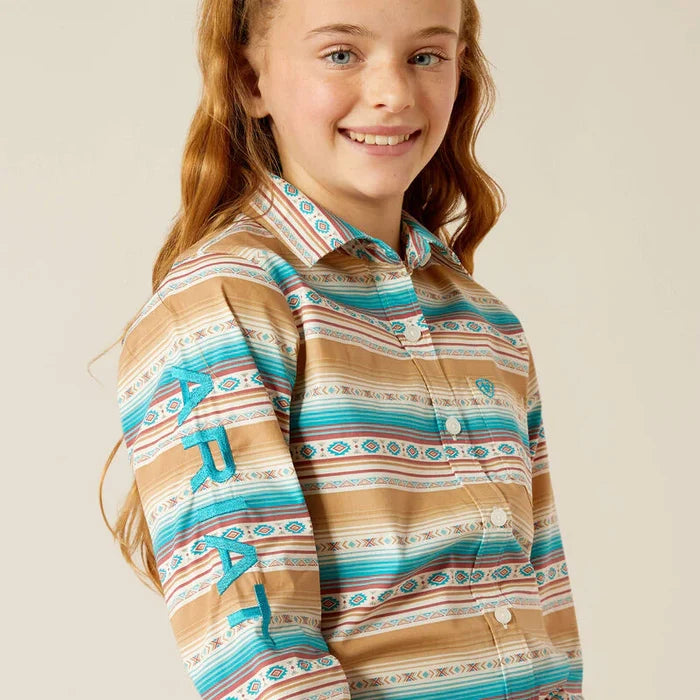 Girl's Ariat blue and brown Serape Print long sleeve Team logo shirt. Close up of Ariat logo on sleeve.