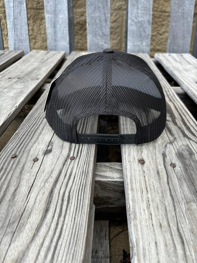 A black snapback cap with a embroidered praying cowboy design. Rear View