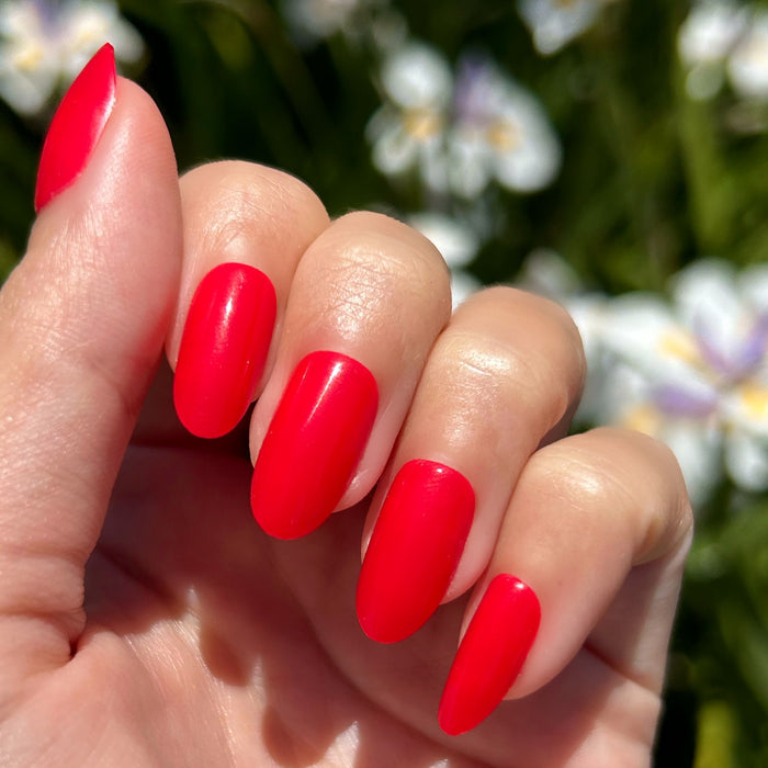 Hibiscus - Press-On | Medium | Oval showing medium oval bright tropical pink press-on nails outdoors on natural hand