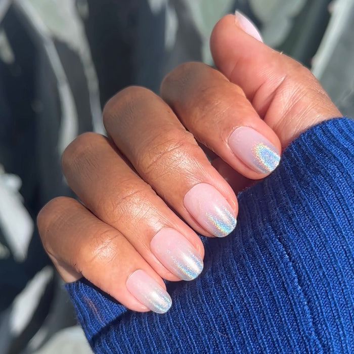 Hand with Holographic Gradient - Press-On | Short | Round false nails featuring neutral base and shimmering holographic tips on sweater sleeve