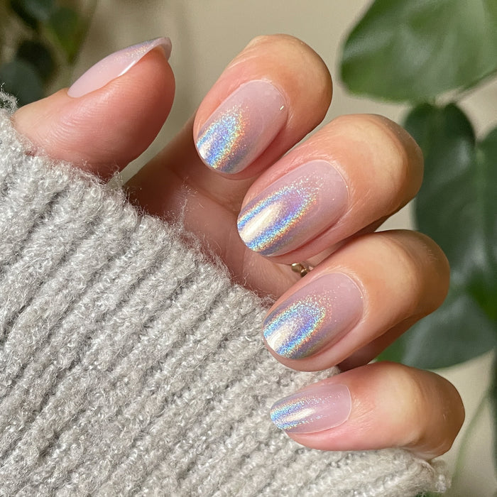 Holographic Gradient - Press-On | Short | Round nails with neutral base and rainbow shimmer on hand wearing gray knit sweater