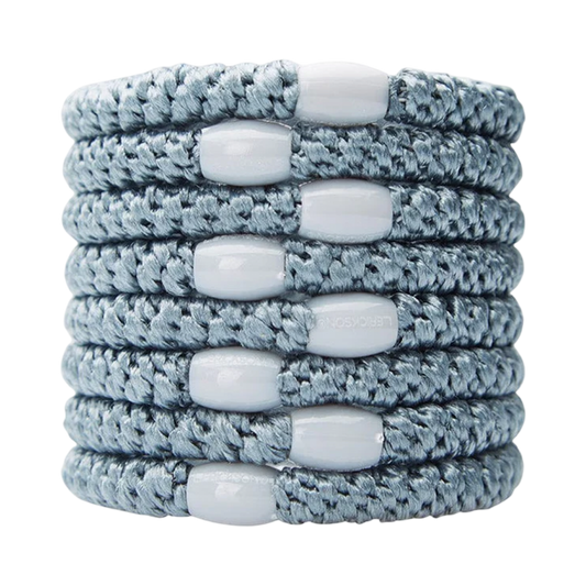 Stack of gray braided bracelets with white beads on a white background