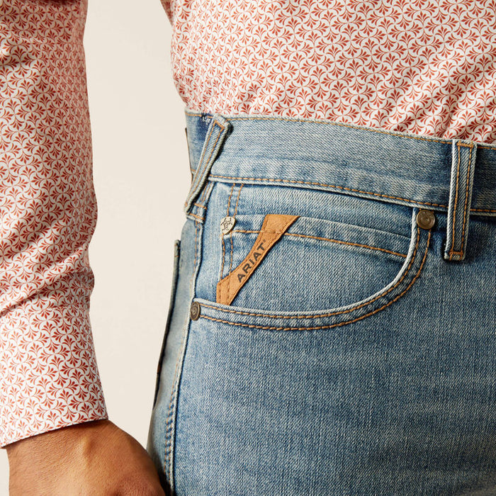 Men's Ariat M7 straight jean in a light wash. Close up of front pocket featuring Ariat logo tag.