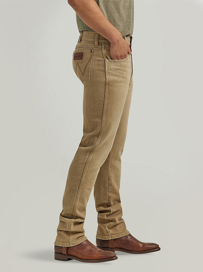 Side view of men's Wrangler Retro slim fit straight leg saddle jeans with a color wash effect.  Shown is the front right scoop pocket, a right coin pocket and the back pocket with the stitched "W" and leather logo patch. All pockets have corner rivets. The jeans are stacked on the boots.