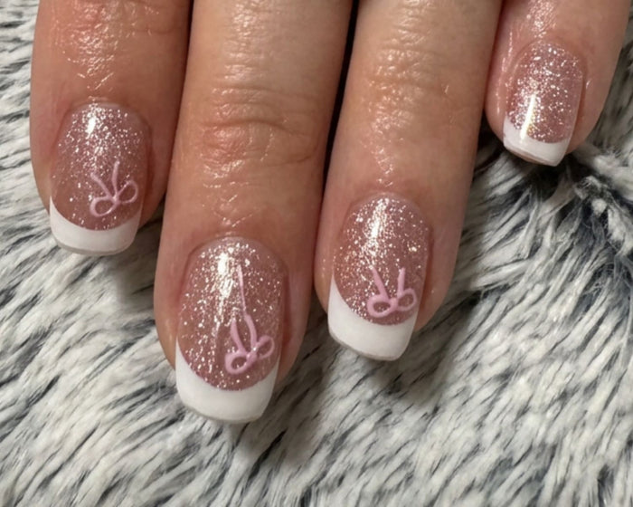 Mini Bows nail decals layered over a champagne and French rose manicure