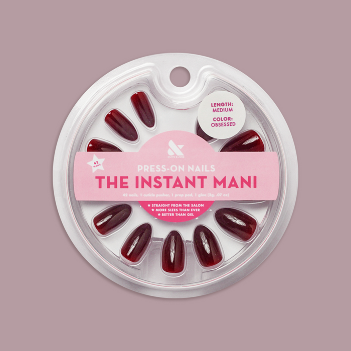 Obsessed - Press-On | Medium | Almond showing dark red medium almond false nails in clear circular package on mauve background