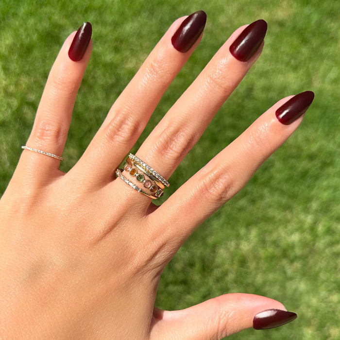 Obsessed - Press-On | Medium | Almond showing hand outdoors with dark ruby almond press-on manicure and gold rings