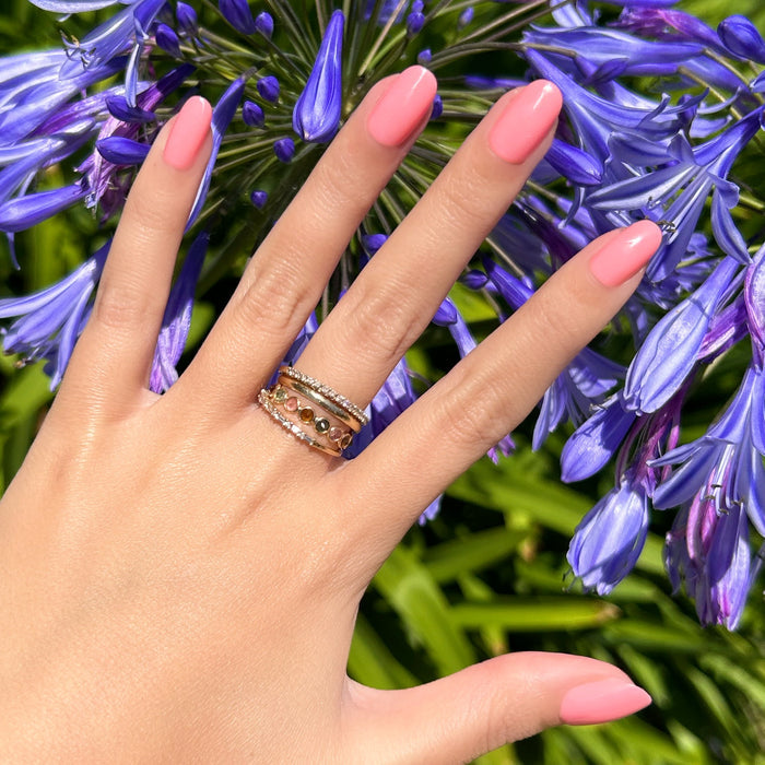 Pen Pal - Press-On | Short | Round showing bright bubblegum pink short round false nails on hand outdoors with purple flowers background