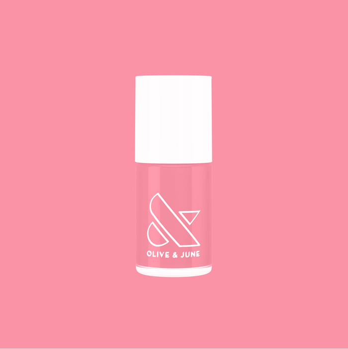 Bottle of Pen Pal bubblegum pink quick dry polish by Olive and June on solid pink background