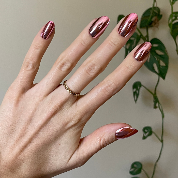 Pink Mirror Chrome - Press-On | Medium | Oval showing hand with medium oval pink chrome press-on manicure indoors