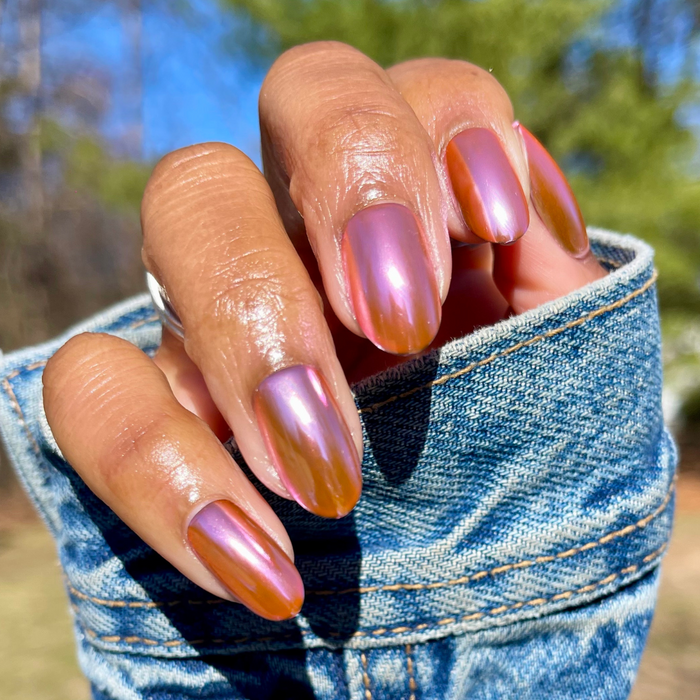 Pink Mirror Chrome - Press-On | Medium | Oval showing hand with medium oval pink chrome press-on manicure outdoors in natural light