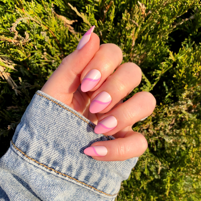 Pink Simple Twist - Press-On | Medium | Almond false nails featuring a soft pink mani with a subtle curved twist design outdoors