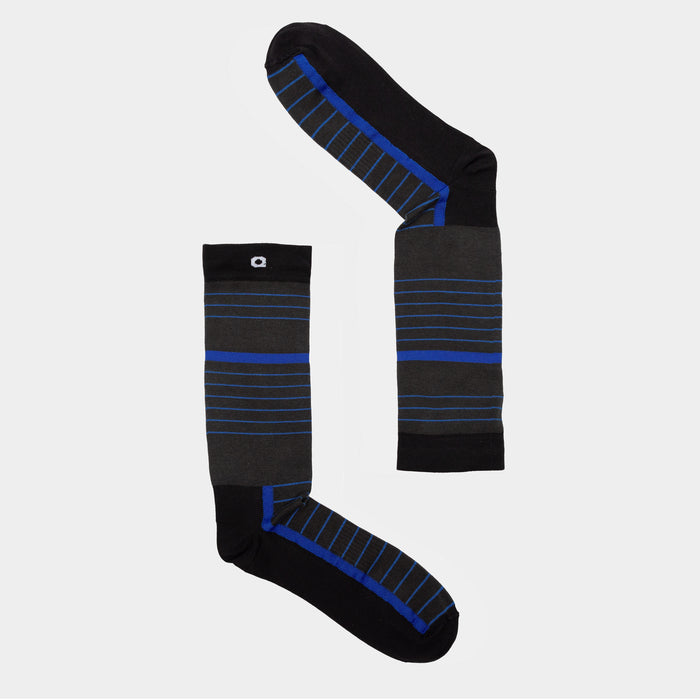 Two black socks with blue and gray horizontal stripes are arranged on a light gray background, one laid out vertically and the other horizontally to form an L shape.