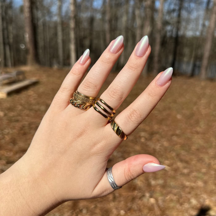 Purple Puka - Press-On | Medium | Almond showing iridescent lavender medium almond mani on hand with gold rings outdoors