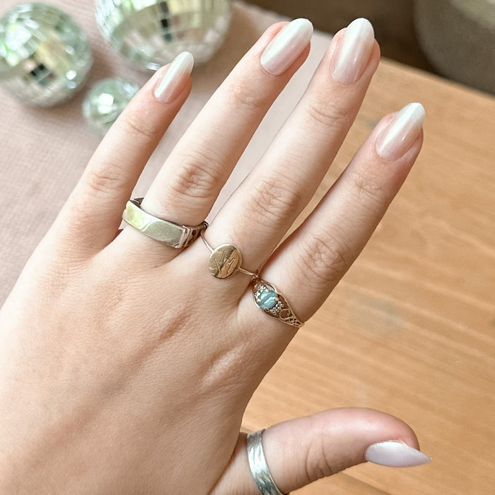 Purple Puka - Press-On | Medium | Oval showing iridescent lavender medium oval false nails on hand with rings indoors