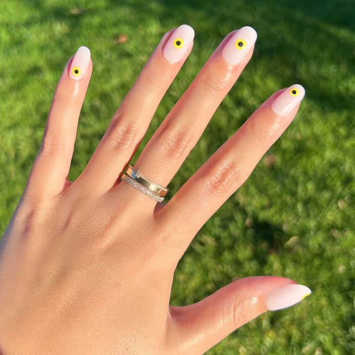 Scattered Sunflower - Press-On | Short | Round showing short round press-on nails with single sunflower designs on hand outdoors