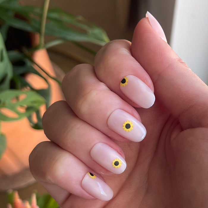 Scattered Sunflower - Press-On | Short | Round showing short round nails with small sunflower designs on natural hand indoors