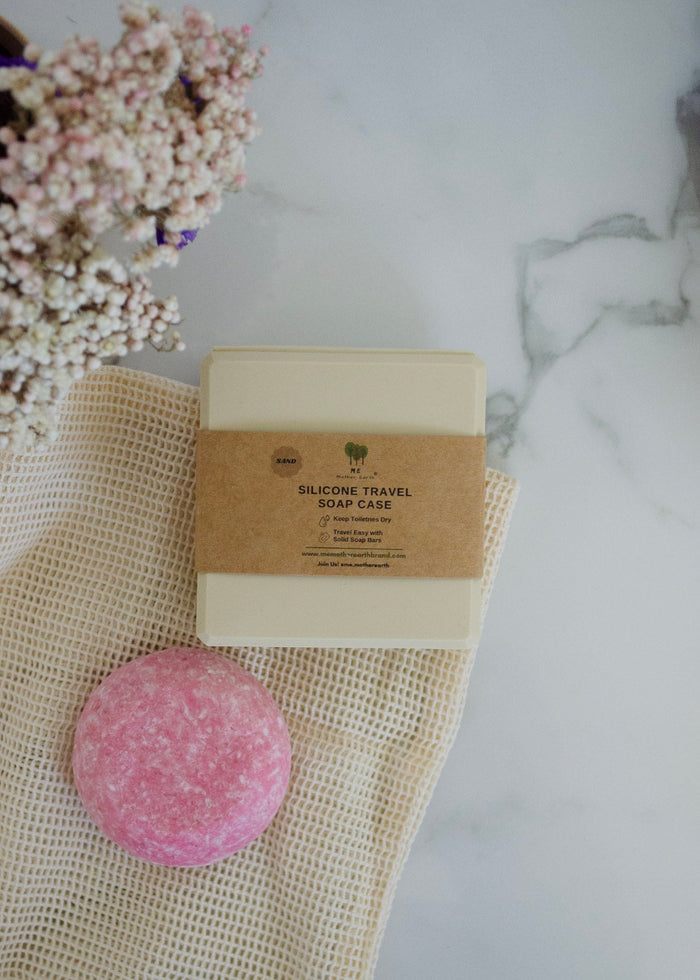Pink silicone soap on a textured cloth with a cardboard packaging label on a marble surface.