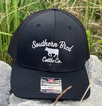 A black Southern Bred 'O.G.' Cattle Co. Richardson 112PL R-Flex adjustable snapback cap with a white logo and a mesh back.