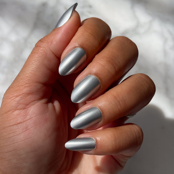 Hand with medium skin tone wearing Steel Velvet - Press-On | Medium | Almond false nails in metallic silver velvet finish under natural light