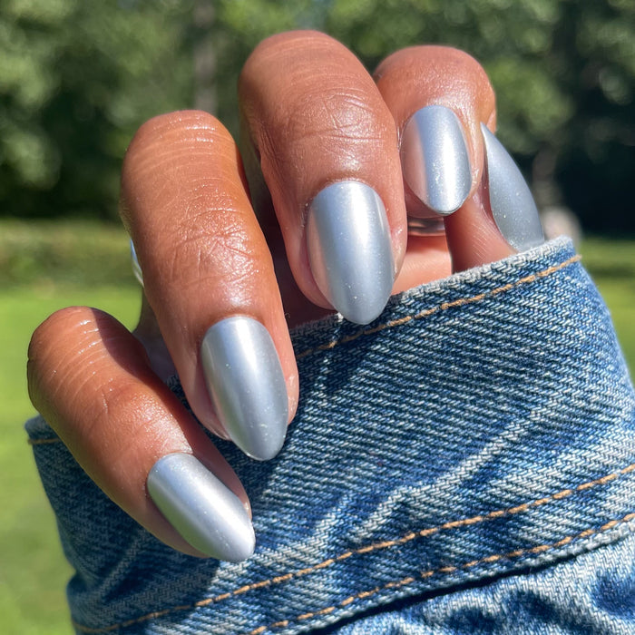 Hand with medium skin tone wearing Steel Velvet - Press-On | Medium | Almond nails in smooth metallic silver velvet finish outdoor sunlight
