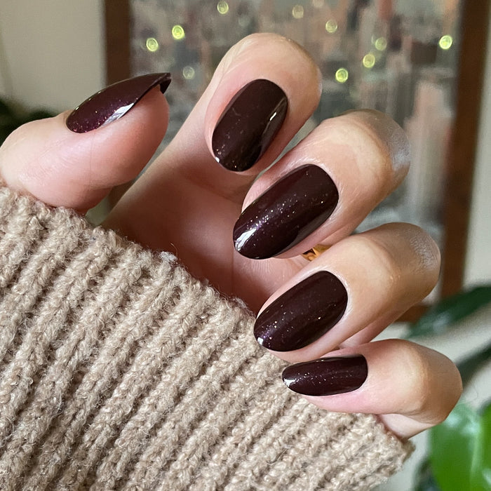 To Me, You Are Perfect - Press-On | Medium | Oval deep plum metallic shimmer false nails on hand with cozy sweater background