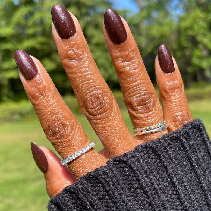 To Me, You Are Perfect - Press-On | Medium | Oval false nails in deep plum metallic shimmer on hand outdoors with rings