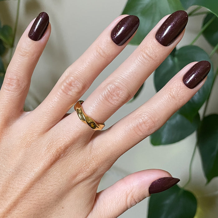 Hand with To Me, You Are Perfect - Press-On | Medium | Oval deep plum metallic shimmer press-on false nails and gold ring