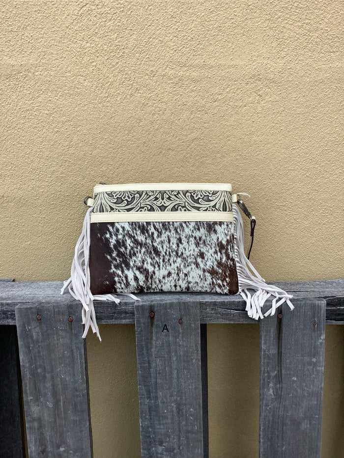 This cowhide and tooled leather crossbody bag features fringe sides and zips closed. The strap is removable and adjustable. Front View A