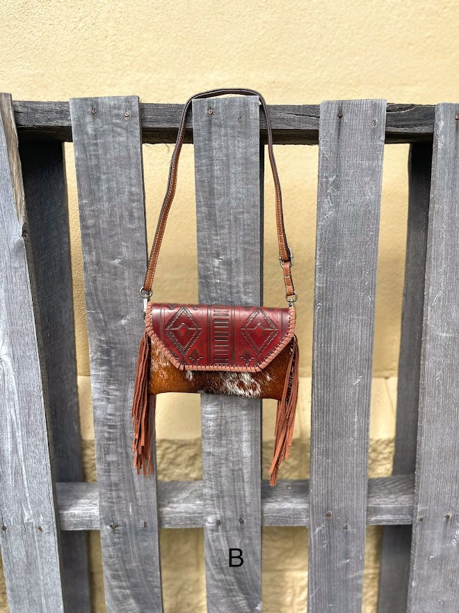 Cowhide purse with Brown leather embossed flap and tassel detail. Has a removable, adjustable shoulder strap and a wristlet strap. Front View B