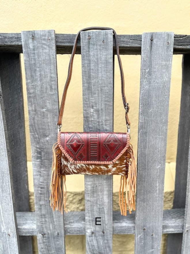 Cowhide purse with Brown leather embossed flap and tassel detail. Has a removable, adjustable shoulder strap and a wristlet strap. Front View E